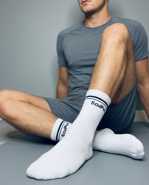 Man in recovery wearing SculPtd grip socks during a restorative Pilates session