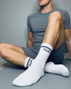 Man recovering after Pilates workout wearing SculPtd Retro Alto Crew Style Pilates Grip socks in color White and Black combination